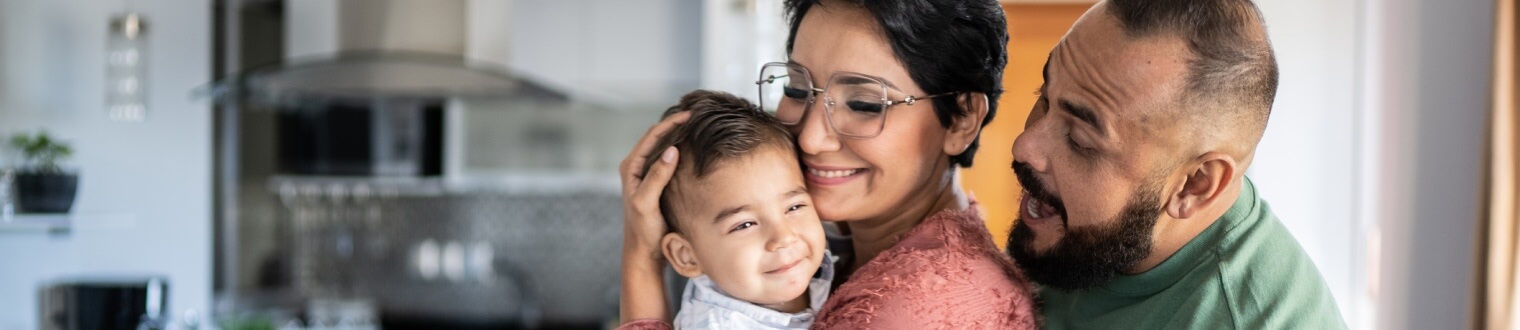 Wife holding baby while husband smiles