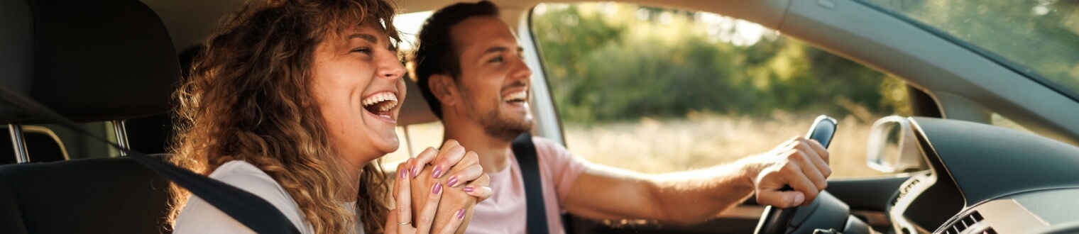 Couple laughing while driving in car