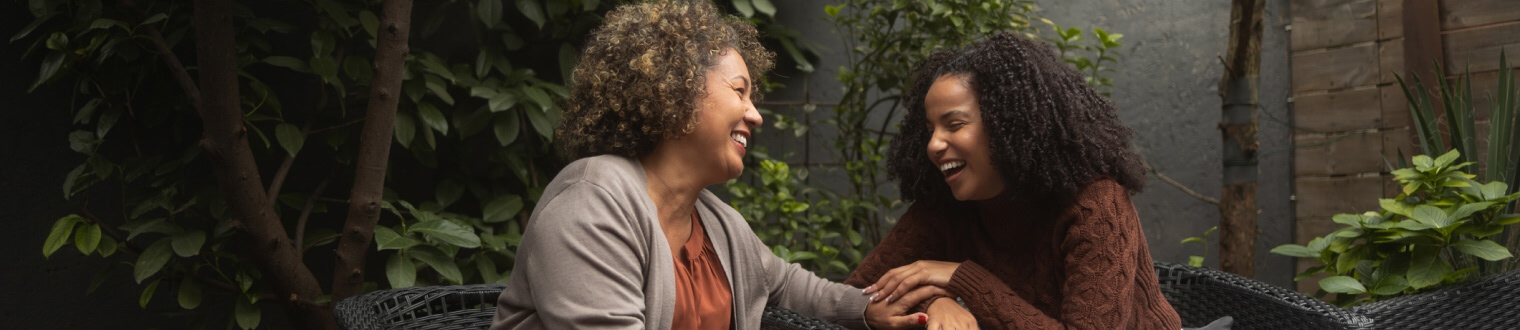 Mature woman and younger woman laughing together outside