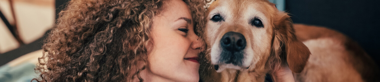 Woman smiling while looking at her dog