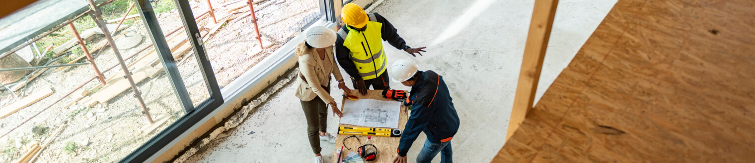 Construction workers reviewing plans on site.