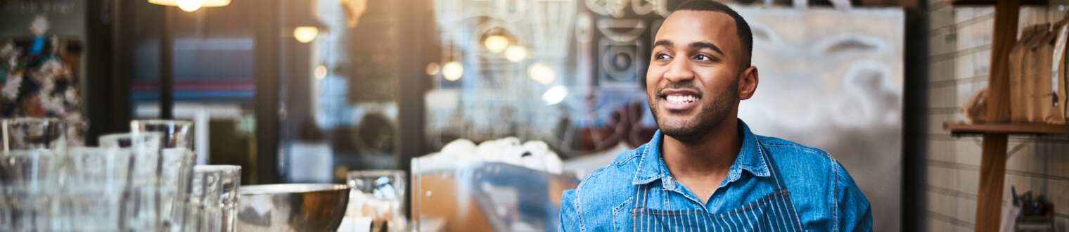 Business owner smiling while working in his restaurant.